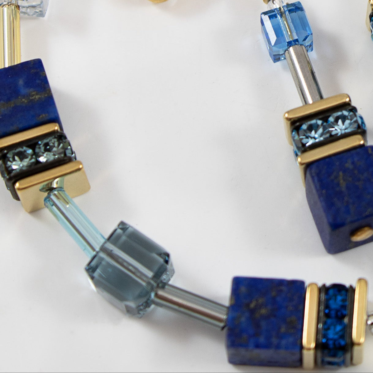 Jewelry set with blue and gold beads on a white background
