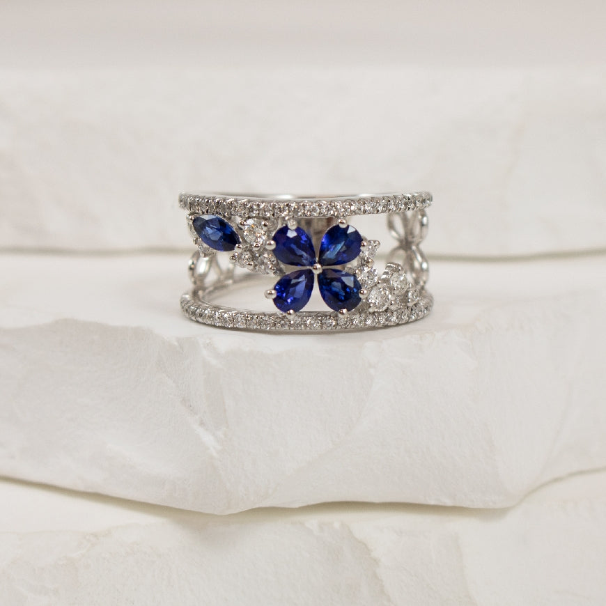 18KW Open Concept Floral Sapphire & Diamond Ring  
18K White Gold Sapphire & Natural Diamond Ring
0.90 Total Natural Sapphire Weight
0.50 Total Natural Diamond Weight SI1-VS2 Clarity, G Colour
Finger Size 6