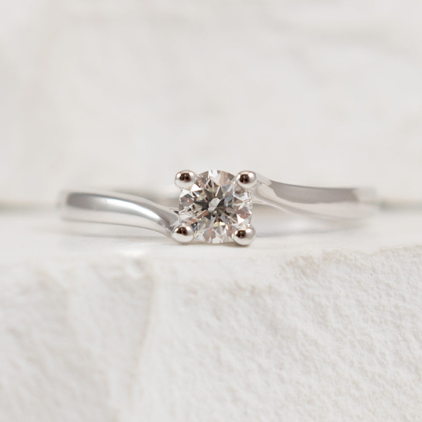 14KW Petite Diamond Twist Solitaire Ring          
14K White Gold Natural Diamond Solitaire Ring
0.25 Carat Round Brilliant Cut Diamond of I1-2 Clarity, H Colour
Finger Size 6.25