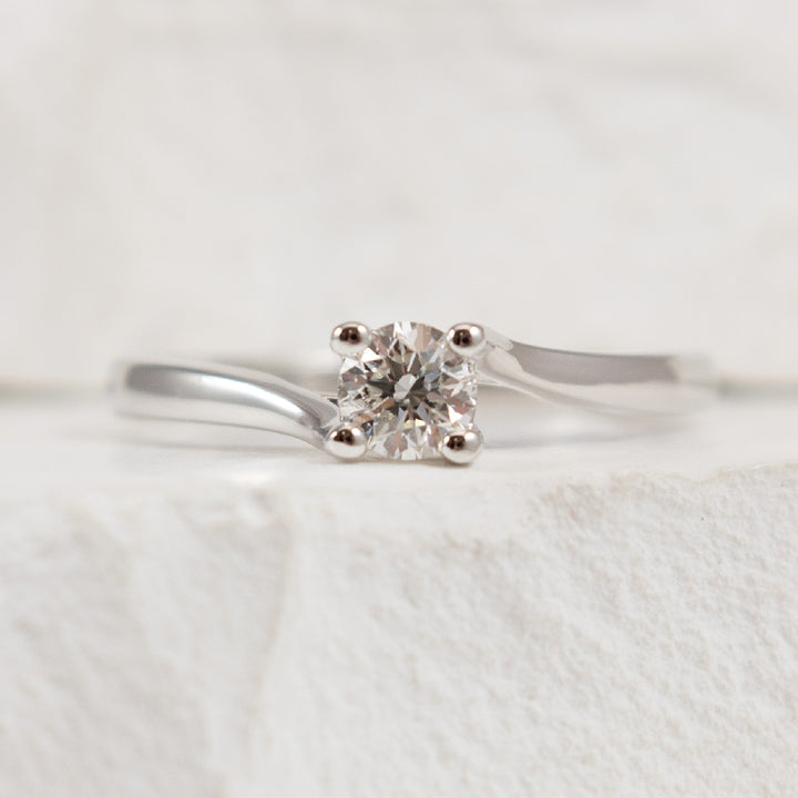 14KW Petite Diamond Twist Solitaire Ring          
14K White Gold Natural Diamond Solitaire Ring
0.25 Carat Round Brilliant Cut Diamond of I1-2 Clarity, H Colour
Finger Size 6.25