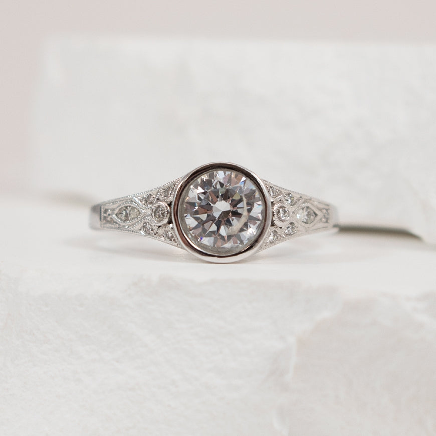 14KW Vintage Diamond Bezel Engagement Ring Setting
14K White Gold Diamond Accented Vintage Bezel Set Engagement Ring Setting
Center - To Hold 0.80 Carat Round Brilliant Cut Diamond
Accent - 0.12 Carats Natural Diamonds of SI1 Clarity, H Colo