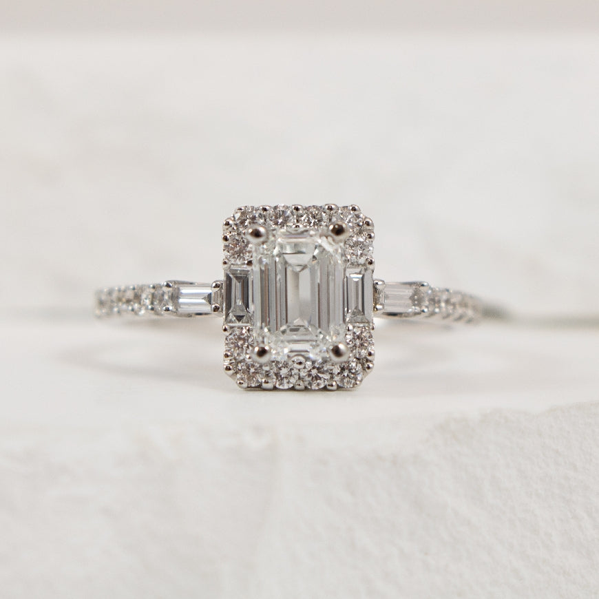 14KW Emerald Cut Halo Diamond Engagement Ring     
14K White Gold Canadian Natural Diamond Emerald Cut Halo Engagement Ring 
Center - 0.90 Carat Emerald Cut Canadian Natural Diamond of VS1 Clarity, H Colour, Very Good Cut 
 
Accent - 0.45 Car