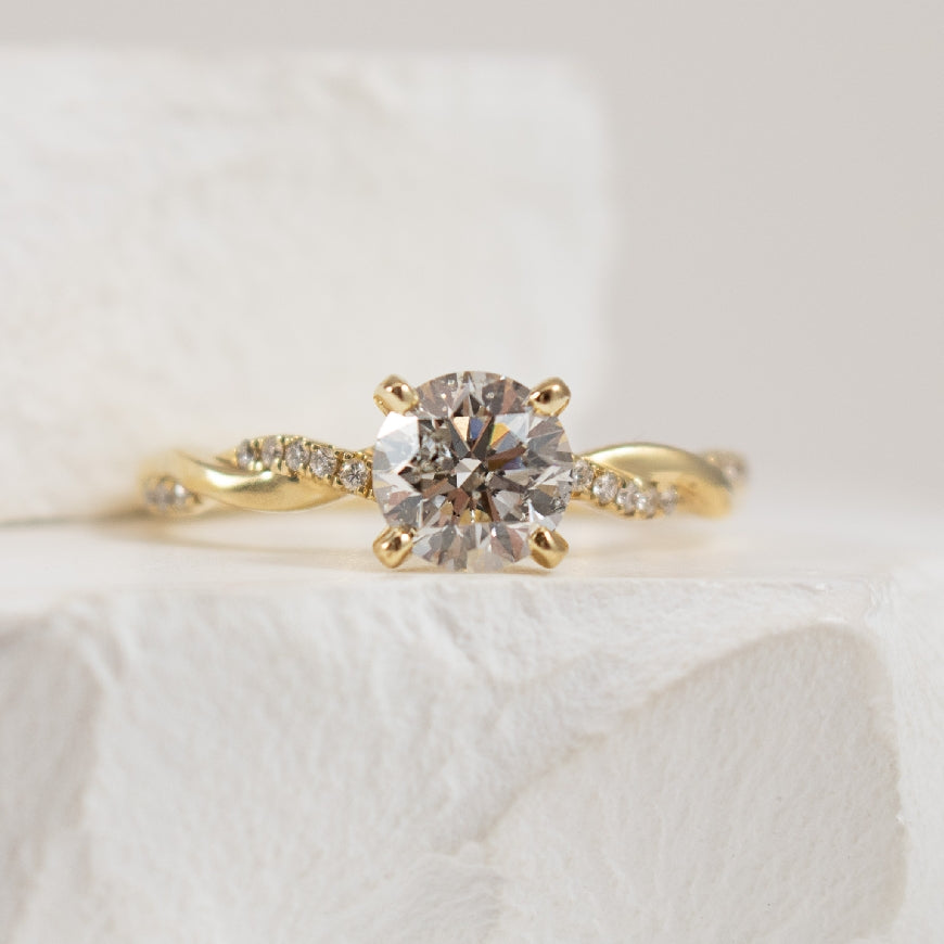 14K Yellow Gold Roman & Jules Canadian Natural Diamond Twist Engagement Ring 
Center - 1.01 Carat Round Brilliant Cut Canadian Natural Diamond of I1 Clarity, G Colour, Very Good Cut 
Accent - 0.08 Carats Round Brilliant Cut Natural Diamonds of