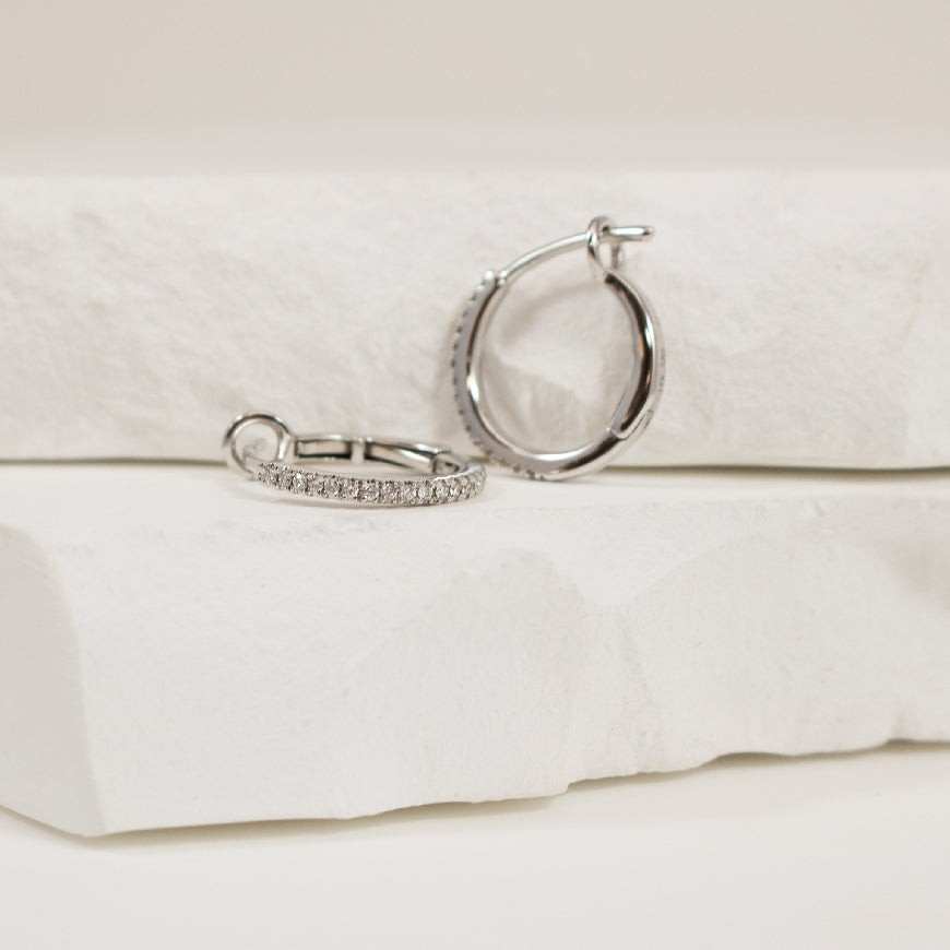 14KW Petite Diamond Huggie Hoop Earrings             
14K White Gold Roman & Jules Natural Diamond Hoop Earrings
0.10 Total Natural Diamond Weight SI Clarity, GH Colour
Earring Closure Huggie Hoop
