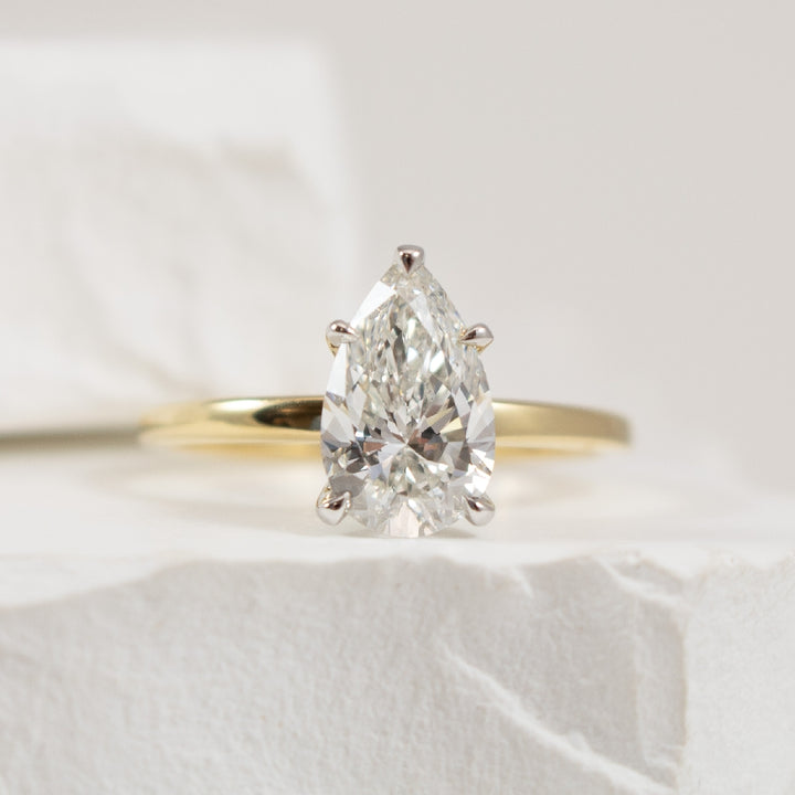 14KY Diamond Solitaire & Hidden Halo Engagement Ring
14K Yellow Gold Lab Grown Diamond Solitaire & Hidden Halo Engagement Ring
Center - 1.53 Carat Pear Shaped Lab Grown Diamond VS2 Clarity, F Colour, Excellent Cut, IGI Certified 
Accent - 0.
