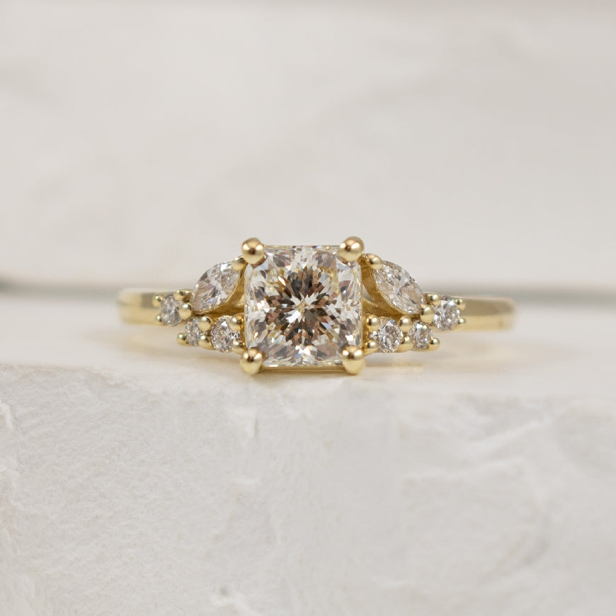14KY Canadian Forevermark Diamond Engagement Ring 
14K Yellow Gold Natural Canadian Forevermark Diamond Accented Engagement Ring 
Center - 1.01CT Radiant Cut Natural Canadian Forevermark Diamond of VS2 Clarity, I Colour, Excellent/ Very Good Cu