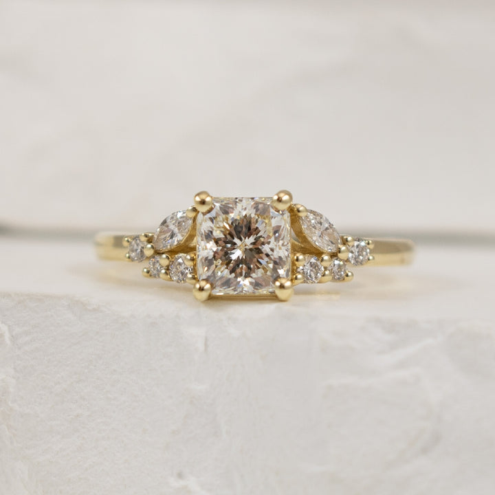 14KY Canadian Forevermark Diamond Engagement Ring 
14K Yellow Gold Natural Canadian Forevermark Diamond Accented Engagement Ring 
Center - 1.01CT Radiant Cut Natural Canadian Forevermark Diamond of VS2 Clarity, I Colour, Excellent/ Very Good Cu