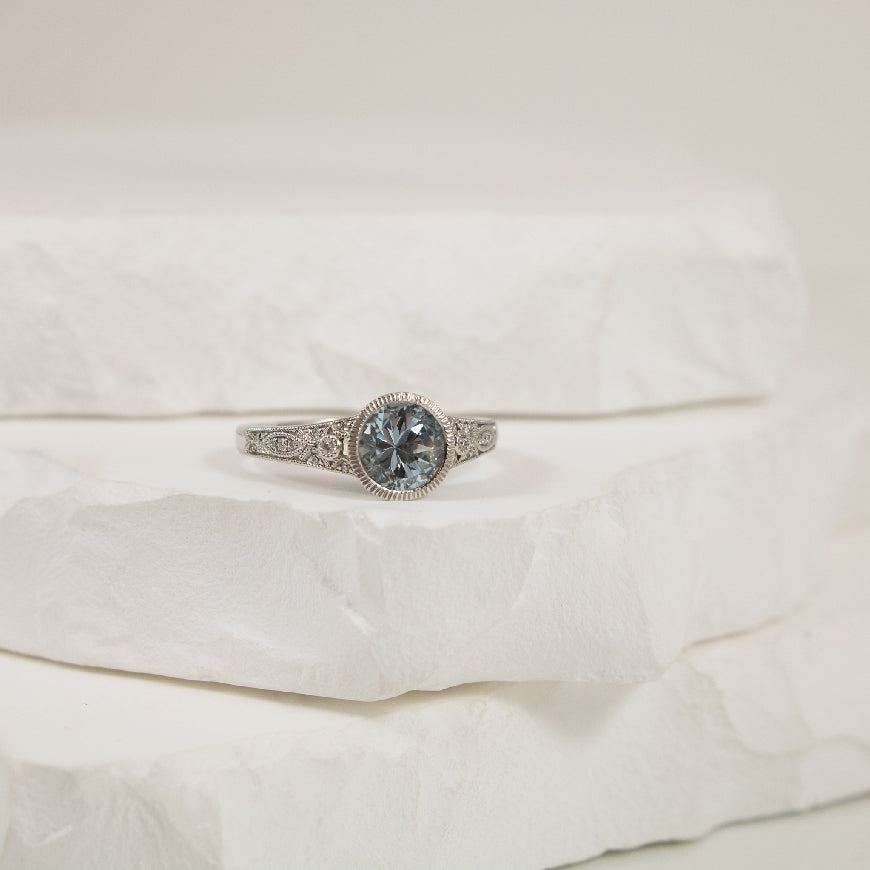14KW Vintage Style Aquamarine & Diamond Bezel Ring 
14K White Gold Aquamarine & Natural Diamond Ring
0.97 Carat Round Cut Aquamarine
0.05 Total Natural Diamond Weight SI1-2 Clarity, GH Colour
Finger Size 6.5
