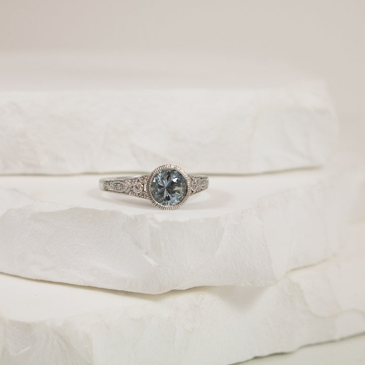 14KW Vintage Style Aquamarine & Diamond Bezel Ring 
14K White Gold Aquamarine & Natural Diamond Ring
0.97 Carat Round Cut Aquamarine
0.05 Total Natural Diamond Weight SI1-2 Clarity, GH Colour
Finger Size 6.5