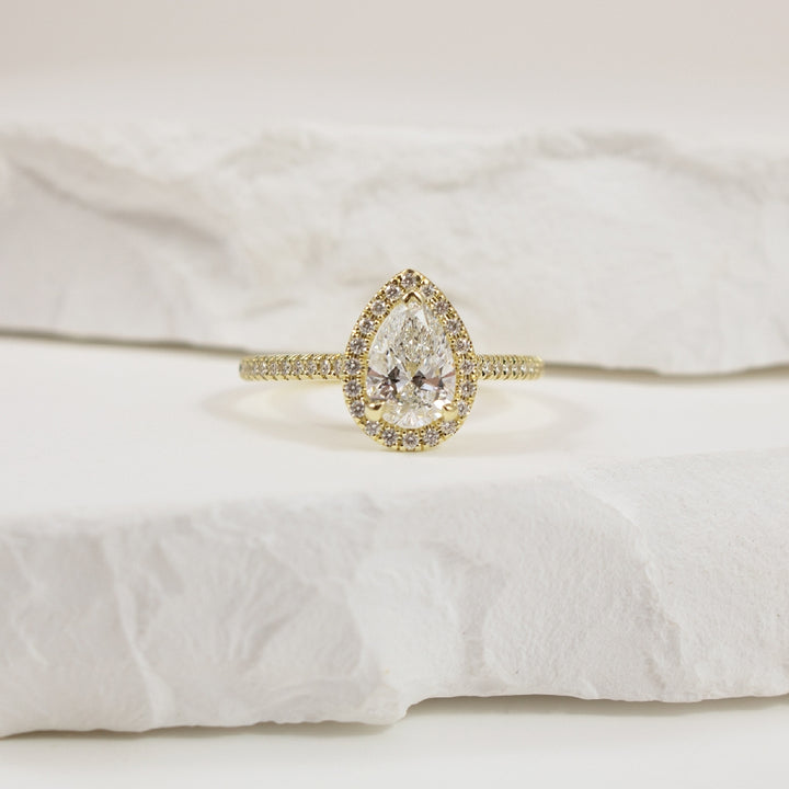 14KY Naledi 1CT Pear Halo Diamond Engagement Ring
14K Yellow Gold Naledi Pear Natural Diamond Halo Engagement Ring 
Center Diamond - 1.00 Carat Pear Shaped Lab Grown Diamond of  VS2 Clarity, D Colour, Excellent/ Very Good Cut, GIA Certified