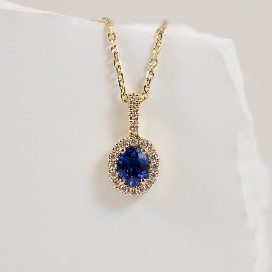 14KY Oval Halo Sapphire & Diamond Necklace        
14K Yellow Gold Roman & Jules Natural Diamond & Sapphire Oval Halo Necklace 
0.47 Carat Oval Sapphire  
0.10 Carats Round Brilliant Cut Natural Diamonds of SI1-2 Clarity, G-H Colour 
Chai