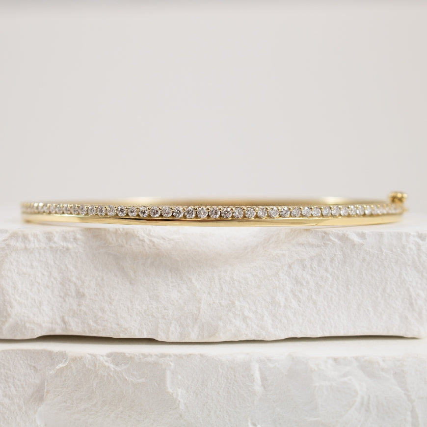 10KY High-Polish & Diamond Hinged Bangle          
10K Yellow Gold 0.75 Carat Natural Diamond Bangle 
0.75 Total Natural Diamond Weight of I1-2 Clarity, H-J Colour 
Hinged w. Saftey Latch