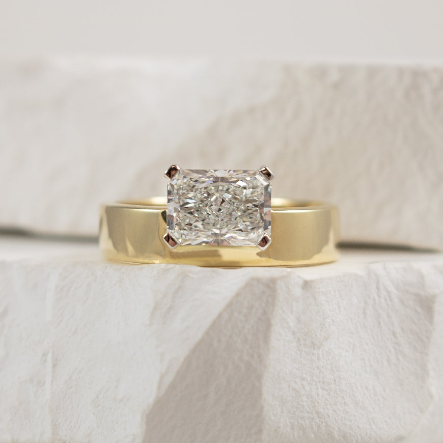 14KY Radiant Cut East-West Diamond Engagement Ring      

14K Yellow Gold Lab Grown Radiant Cut East-West Diamond Solitaire Cigar Band Engagement Ring 

Center - 1.56CT Radiant Cut Lab Grown Diamond of VVS2 Clarity, E Colour, Excellent Cut, IGI C