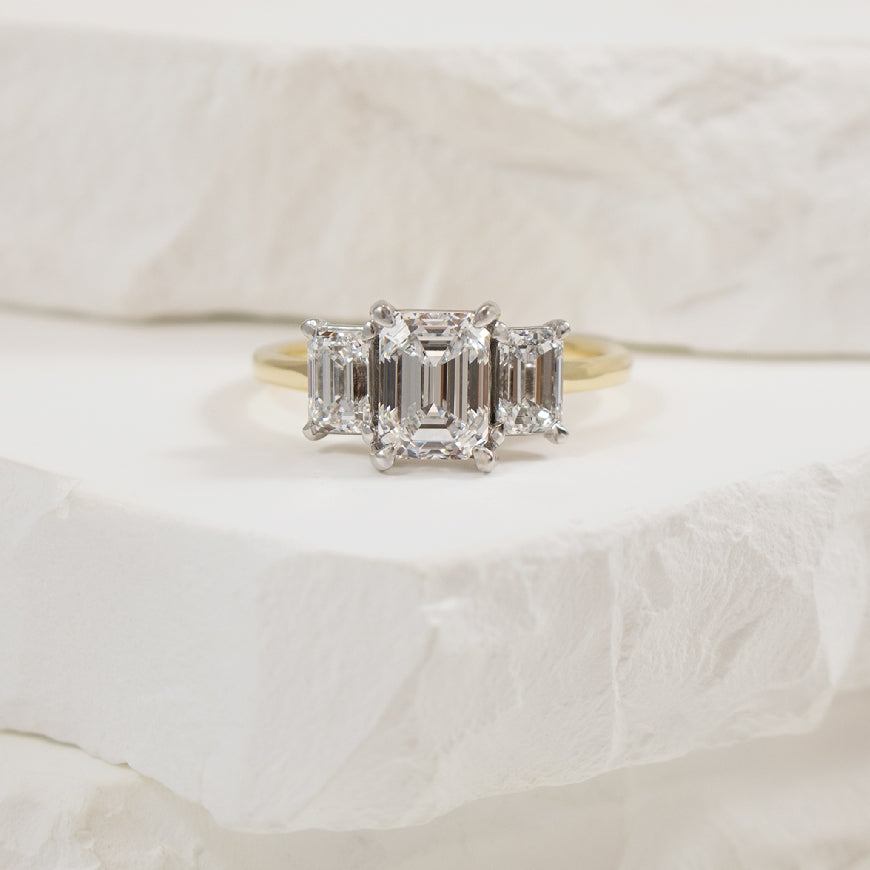 14KY Emerald Cut Trinity Diamond Engagement Ring  

14K Yellow & White Gold Emerald Cut Three Stone Lab Grown Diamond Engagement Ring 

Center - 1.58CT Emerald Cut Lab Grown Diamond of VVS2 Clarity, E Colour, Excellent Cut
 
Accent - 1.01 Carat