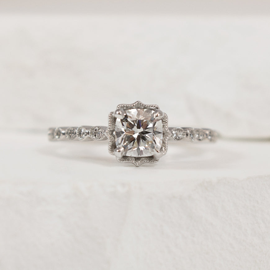 18KW Forevermark Vintage Diamond Engagement Ring  

18K White Gold Forevermark Natural Diamond Cushion Vintage Milgrain Engagement Ring 

Center - 0.92 Carat Cushion Cut Forevermark Natural Diamond of SI2 Clarity, F Colour, Black Label (Ideal), F