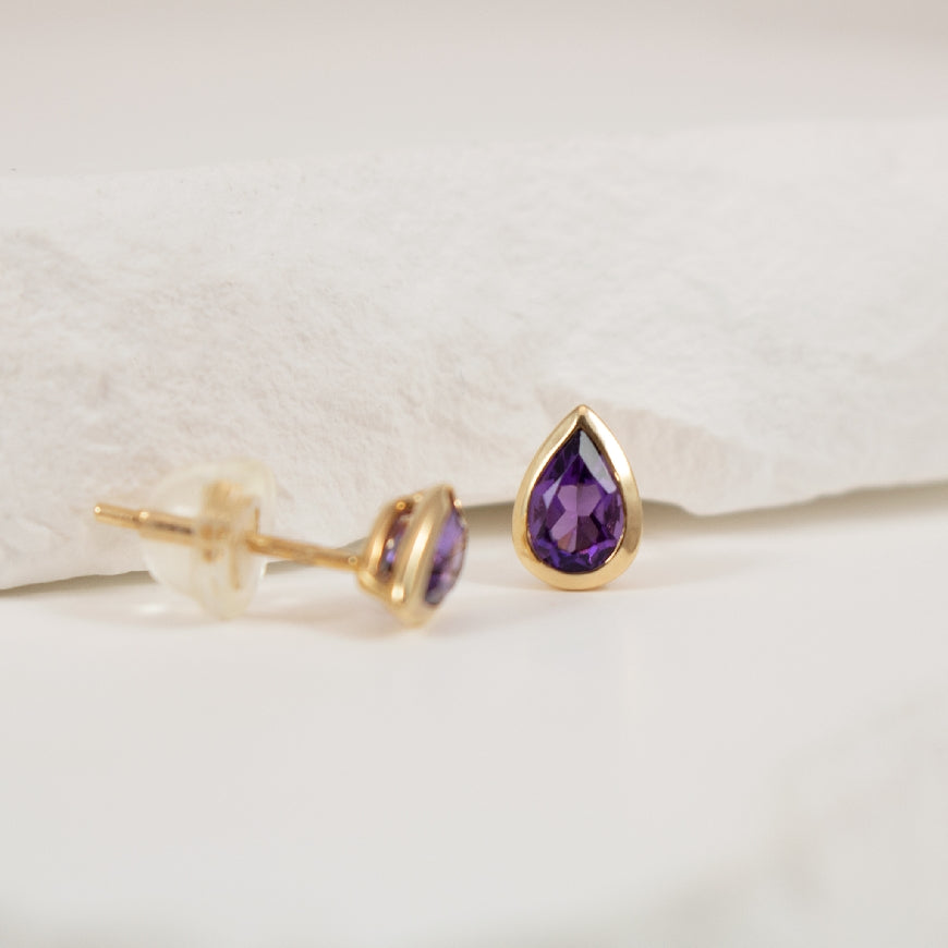 14KY Modern Pear Shaped Bezel Amethyst Earrings  

14K Yellow Gold Bezel Set Amethyst Earrings 

Earring Closure Post with Butterfly Back

0.70 Total Weight

