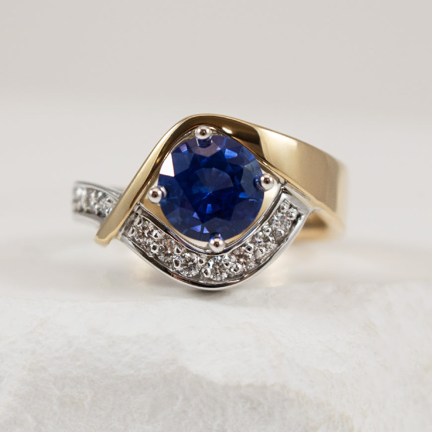 14KW/Y Sapphire & Diamond Asymetrical Ring 

14K Yellow & White Gold Sapphire & Diamond Asymetrical Ring 

1.46 Carat Ceylon Sapphire Medium Strong Very Slightly Violet Blue, Eye-Clean, Exceptional Cut 

0.17 Total Diamond Weight of SI1-2 Calri