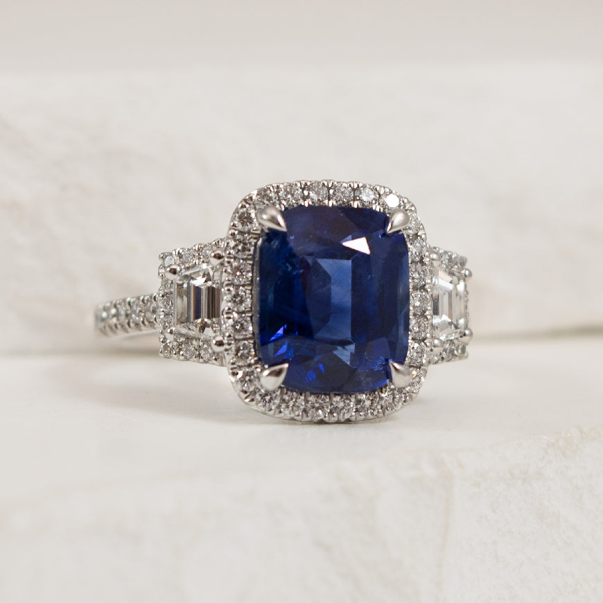 Platinum Sapphire & Diamond Three Stone Halo Ring 

4.57 Carat of Sapphire 

0.83 Total Natural Diamond Weight 

Finger Size 6.5

