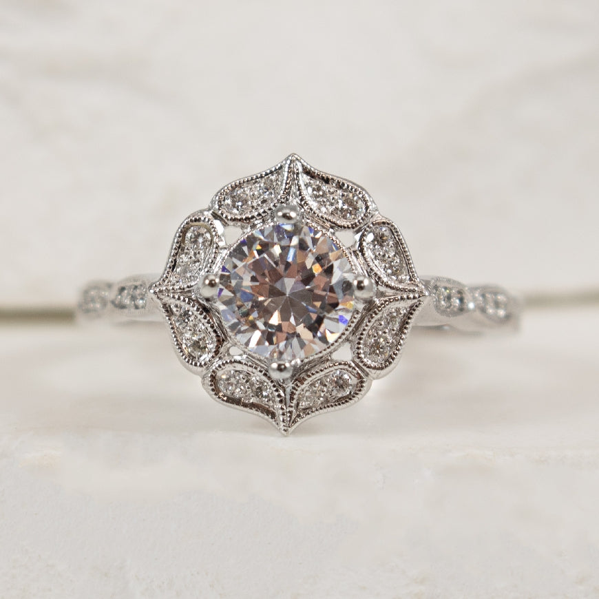 14K White Gold Diamond Accented Vintage Halo Ring Setting

Center - To Hold 0.70CT Round Brilliant Cut Diamond

Accent - 0.13 Total Natural Diamond Weight of SI1 Clarity, H Colour

Finger Size 6.75 

*Price for ring only. This ring can be set