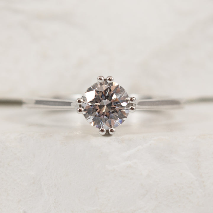 18K White Gold Diamond Accented Ring Setting 

Center - To hold 0.75CT Round Brillaint Cut Diamond

Accent - 0.05 Total Natural Diamond Weight of VS-SI1 Clarity, GH Colour

Finger Size 6.5

*Price for ring only. This ring can be set with your