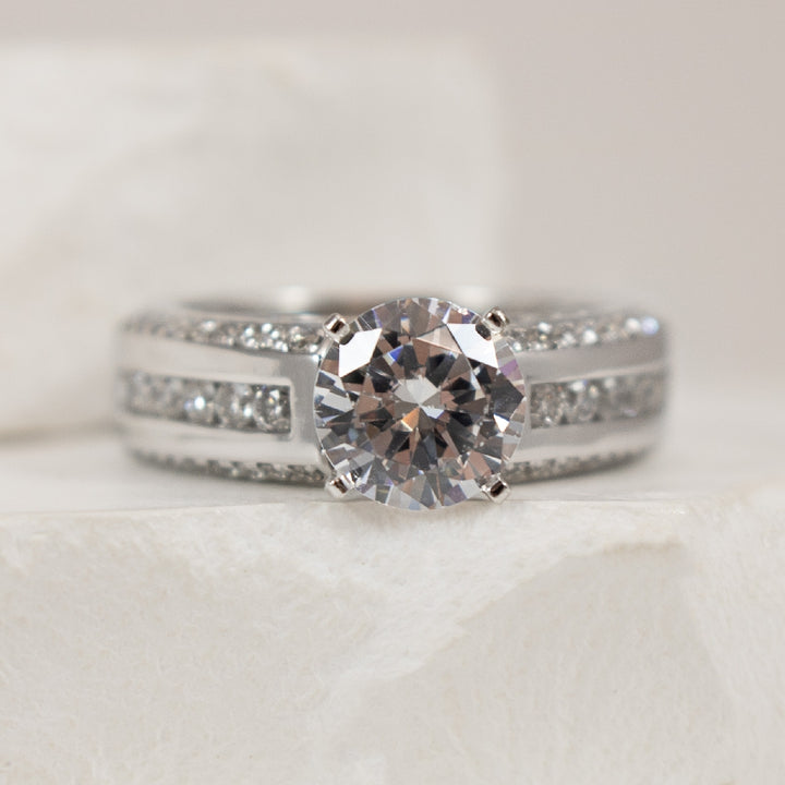 14K White Gold Diamond Accented Ring Setting 

Center - To Hold 1.25CT Round Brilliant Cut Diamond 

Accent - 0.85 Total Natural Diamond Weight of I1 Clarity, GH Colour

Finger Size 6.5

*Price for ring only. This ring can be set with your ch