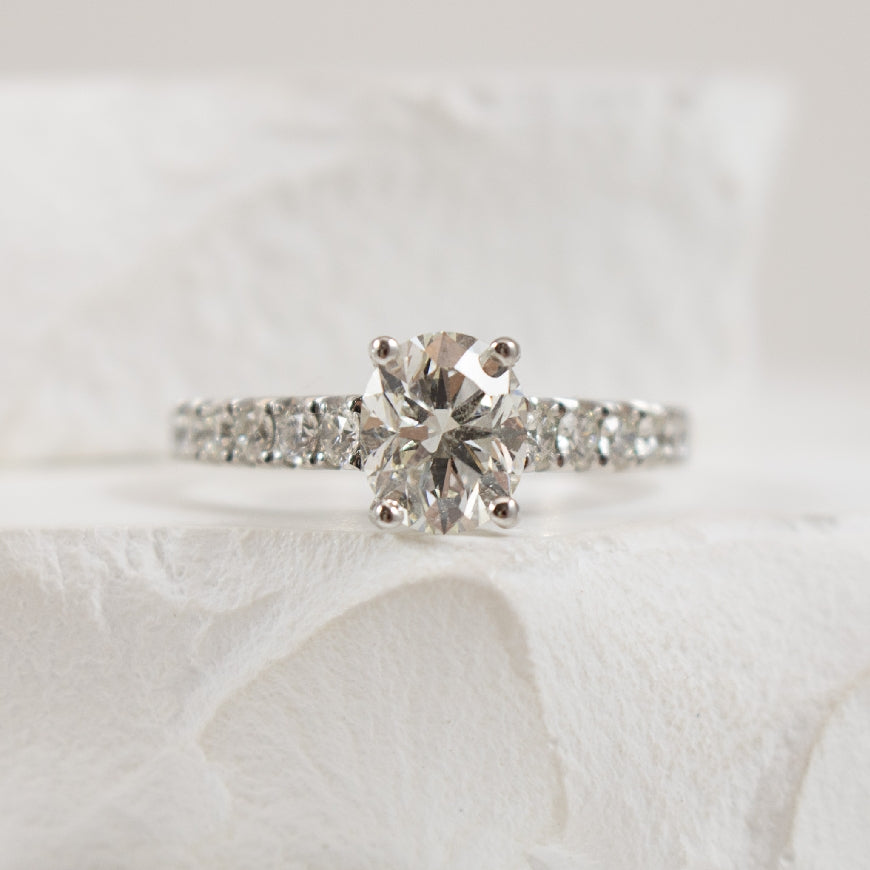 14K White Gold Forevermark Natural Diamond Accented Engagement Ring 

Center - 1.25 Carat Oval Cut Forevermark Natural Diamond VVS2 Clarity, H Colour, Black Label (Ideal) Cut, Forevermark Certified

Accent  - 0.53 Carats Round Brilliant Cut Natur