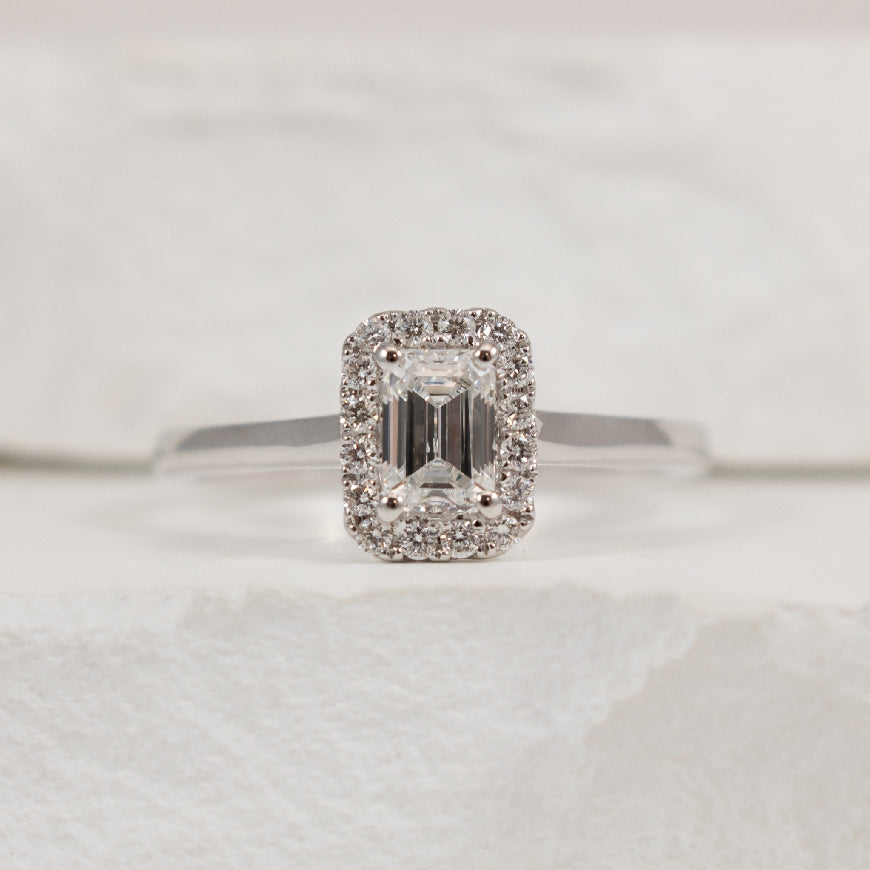 14KW Emerald Cut Halo Diamond Engagement Ring     

14K White Gold Roman & Jules Lab Grown & Natural Diamond Halo Engagement Ring 

Center - 0.50 Carat Emeral Cut Lab Grown Diamond of SI1 Clarity, E Colour, Excellent/ Very Good Cut, IGI Certified