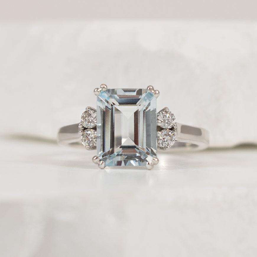 10KW Double Claw Aquamarine & Diamond Ring         

10K White Gold Aquamarine & Canadian Diamond Ring 

Emerald Cut Aquamarine 

0.16 Total Diamond Weight Round Brilliant Cut Canadian Diamonds of VS1 Clarity, H Colour  

Finger Size 5