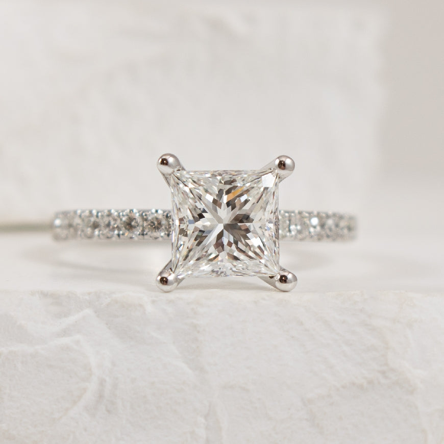 14K White Gold S.Kashi Natural Diamond Princess Cut Accented Engagement Ring 
 
Center - 1.70 Carat Princess Cut Natural Diamond of SI1 Clarity, G Colour, Excellent Cut, GIA Certified 

Accent - 0.46 Carats Round Brilliant Cut Natural Diamonds of