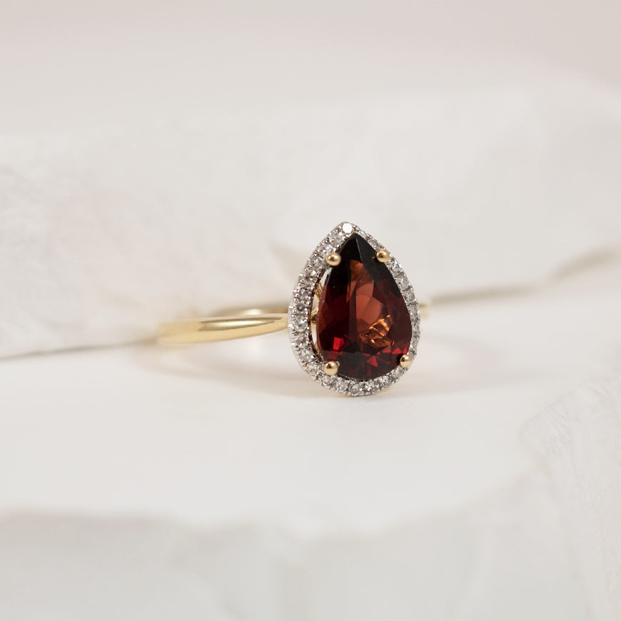 14KY Pear Shaped Garnet & Diamond Accented Ring    

10K Yellow Gold Garnet & Natural Diamond Halo Ring

0.14 Total Natural Diamond Weight

Finger Size 6.25
