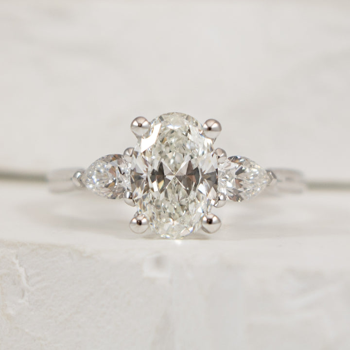 14KW 1.50CT Oval Trinity Diamond Engagement Ring  

14K White Gold Gabriel & Co. Oval Cut & Pear Shaped Three Stone Natural Diamond Engagement Ring 

Center - 1.50CT Oval Cut Natural Diamond of SI1 Clarity,  G Colour, Excellent Cut 

Accent - 0