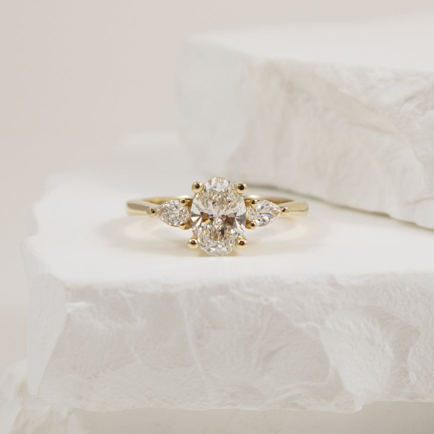 14KY Oval & Pear Trinity Diamond Engagement Ring  

14K Yellow Gold Lab Grown Diamond Three Stone Engagement Ring 

Center - 1.02CT Oval Cut Lab Grown Diamond of VS1 Clarity, F Colour, Excellent/ Excellent/ Excellent Cut, GCAL Certified 

Accen