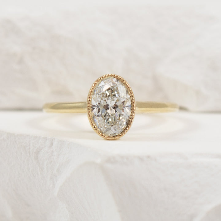 14KY 1.03CT Oval Cut Bezel Diamond Engagement Ring       

14K Yellow Gold Lab Grown Diamond Solitaire Milgrain Bezel Engagement Ring 

Center - 1.03 Carat Oval Cut Lab Grown Diamond of VVS2 Clarity, E Colour, Excellent Cut, CGL Certified 

Ban
