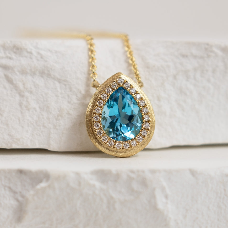 14KY Blue Topaz & Diamond Halo Necklace           

14K Yellow Gold Bassali Blue Topaz & Diamond Halo Necklace 

1.17 Carat of Blue Topaz 

0.08 Total Natural Diamond Weight 

Chain Length 
