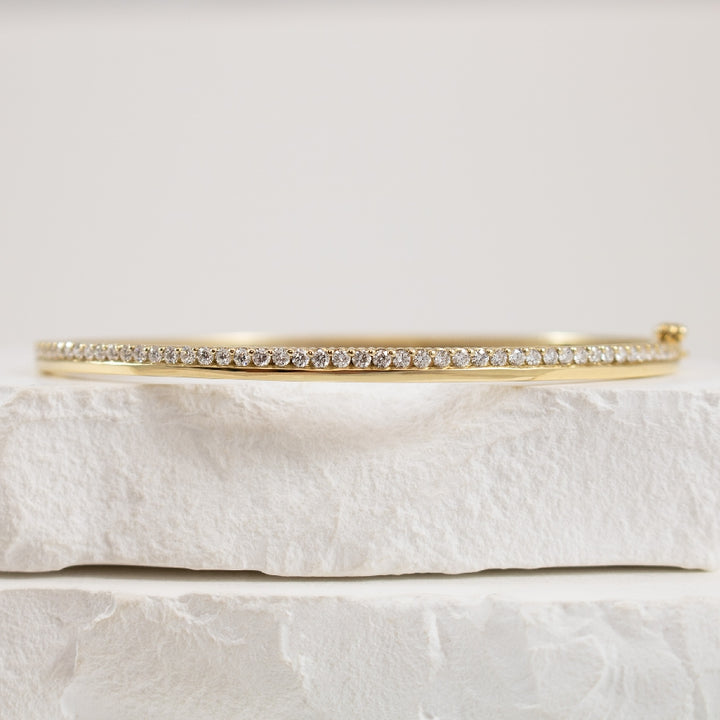 10KY High-Polish & Diamond Hinged Bangle          

10K Yellow Gold 0.75 Carat Natural Diamond Bangle 

0.75 Total Natural Diamond Weight of I1-2 Clarity, H-J Colour 

Hinged w. Saftey Latch 