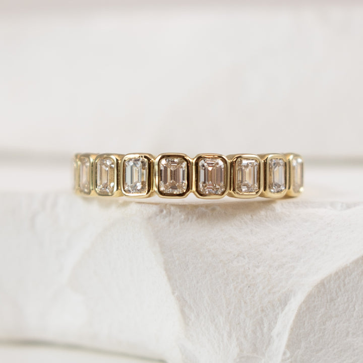 14KY Emerald Cut Diamond Bezel Set Band                                   

14K Yellow Gold S.Kashi Natural Diamond Emerald Cut Bezel Set Band  

0.80 Carats Total Diamond Weight of SI1-2 Clarity, GH Colour 

Finger Size 6.5 