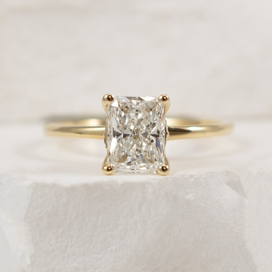 14KY S.Kashi Radiant Cut Diamond Engagement Ring                

14K Yellow Gold S.Kashi Radiant Cut Natural Diamond Solitaire Engagement Ring 

1.33 Carat Radiant Cut Natural Diamond of SI1 Clarity, H Colour, Excellent/ Very Good Cut, GIA Certi