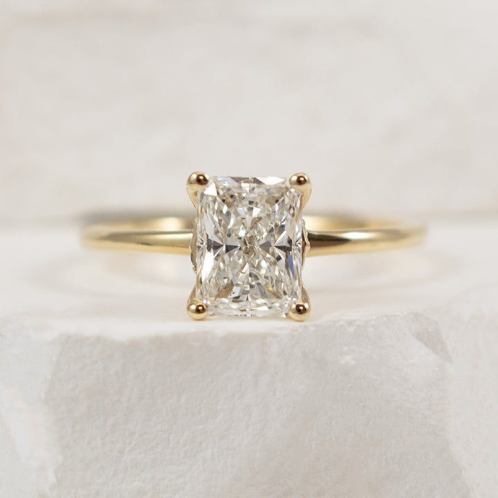 14KY S.Kashi Radiant Cut Diamond Engagement Ring                

14K Yellow Gold S.Kashi Radiant Cut Natural Diamond Solitaire Engagement Ring 

1.33 Carat Radiant Cut Natural Diamond of SI1 Clarity, H Colour, Excellent/ Very Good Cut, GIA Certi