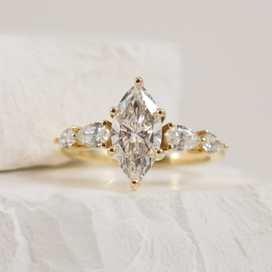 14KY Marquise Cut 5 Stone Diamond Engagement Ring   

14K Yellow Gold Marquise & Pear Lab Grown Diamond Five Stone Engagement Ring 

Center - 1.50 Carat Marquise Cut of VS1 Clarity, E Colour, Excellent/ Excellent Cut, IGI Certified 

Accent - 0