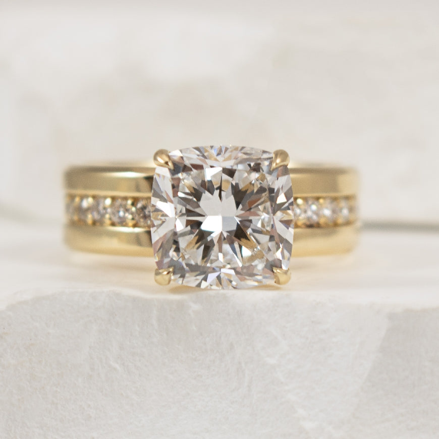 14KY 4.01CT Cushion Cut Diamond Engagement Ring   

14K Yellow Gold 4.01 Carat Cushion Cut Lab Grown & Natural Diamond Cigar Band Engagement Ring 

Center - 4.01 Carat Cushion Cut Lab Grown Diamond of VVS2 Clartiy, E Colour, Excellent/ Excellent 