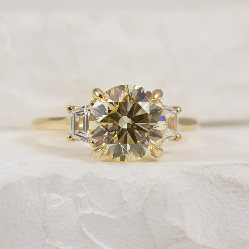 14K 2.93CT Trinity Diamond Engagement Ring        

14K Yellow Gold Round Brilliant & Trapezoid Cut Lab Grown Diamond Lotus Three Stone Engagement Ring 

Center - 2.53 Carat Round Brilliant Cut of VS1 Clarity, Y-Z Colour, Excellent/ Excellent/ Ex
