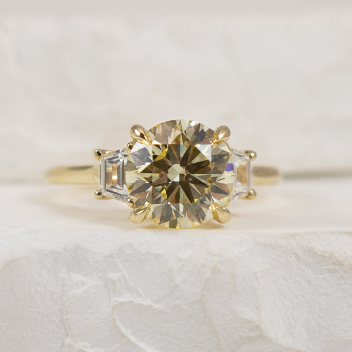 14K 2.93CT Trinity Diamond Engagement Ring        

14K Yellow Gold Round Brilliant & Trapezoid Cut Lab Grown Diamond Lotus Three Stone Engagement Ring 

Center - 2.53 Carat Round Brilliant Cut of VS1 Clarity, Y-Z Colour, Excellent/ Excellent/ Ex