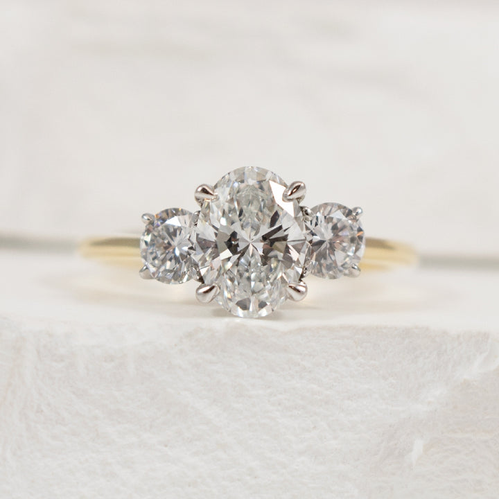 14KY Oval Cut Trinity Diamond Engagement Ring   

14K Yellow & White Gold Oval Lab Grown Diamond Three Stone Engagement Ring 

Center - 2.04 Carat Oval Cut of VS1 Clarity, E Colour, Excellent Cut, IGI Certified 

Accent - 1.00 Carats Round Bril