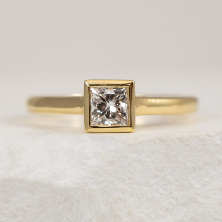 18Y Princess Cut Bezel Diamond Engagement Ring    

18K Yellow Gold Natural Maple Leaf Canadian Diamond  Bezel Engagement Ring 

Center - 0.52CT Princess Cut Canadian Natural Diamond of SI1 Clarity, F Colour, Very Good Cut 

Finger Size 6.5

